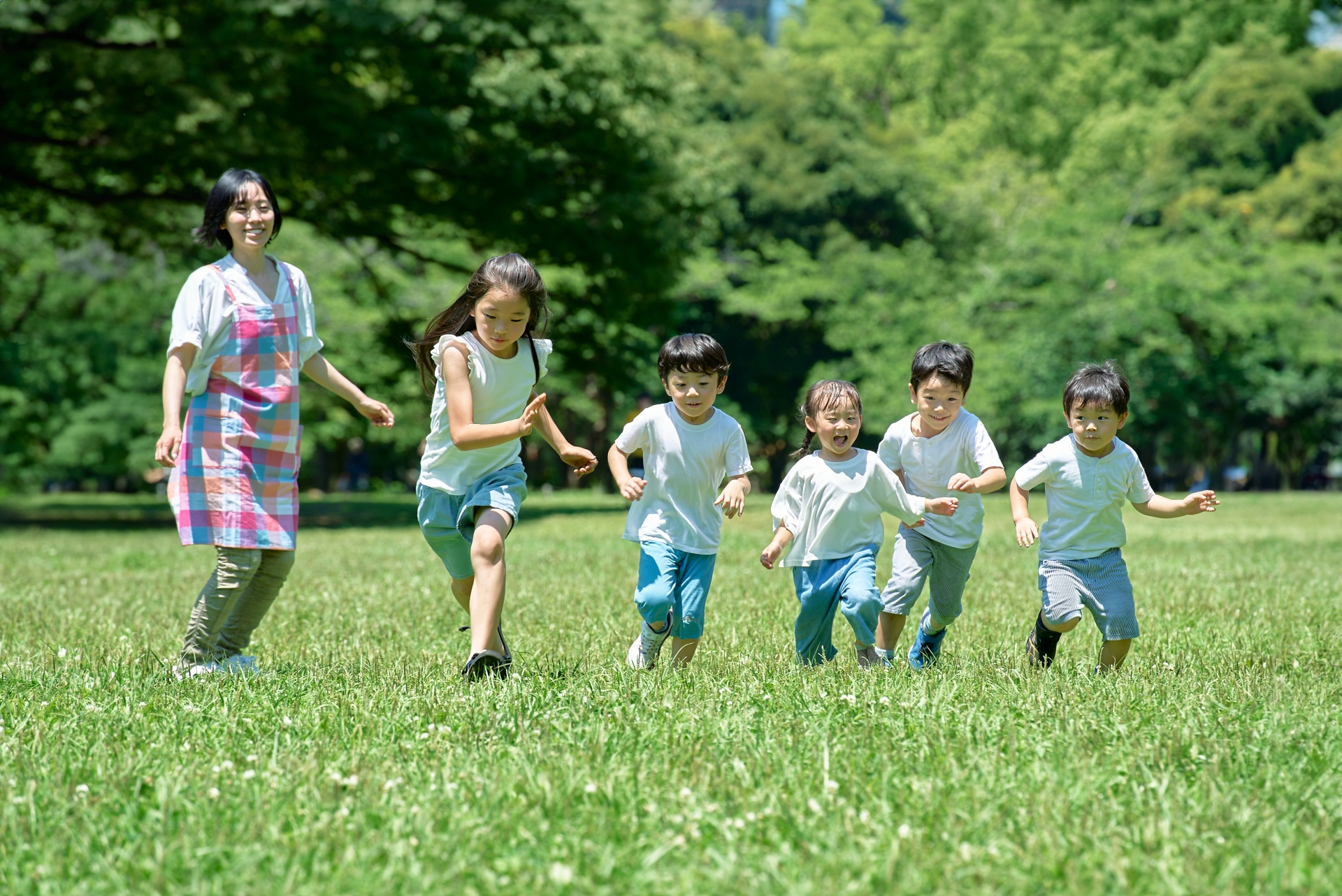 かけっこを見守る保育士