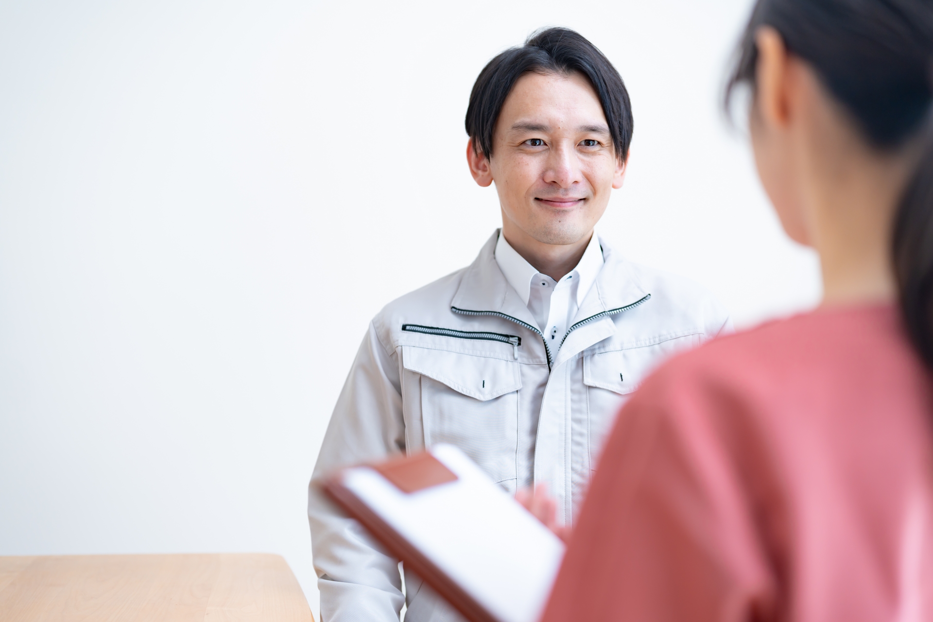 作業着の男性の話を聞く(産業看護師)