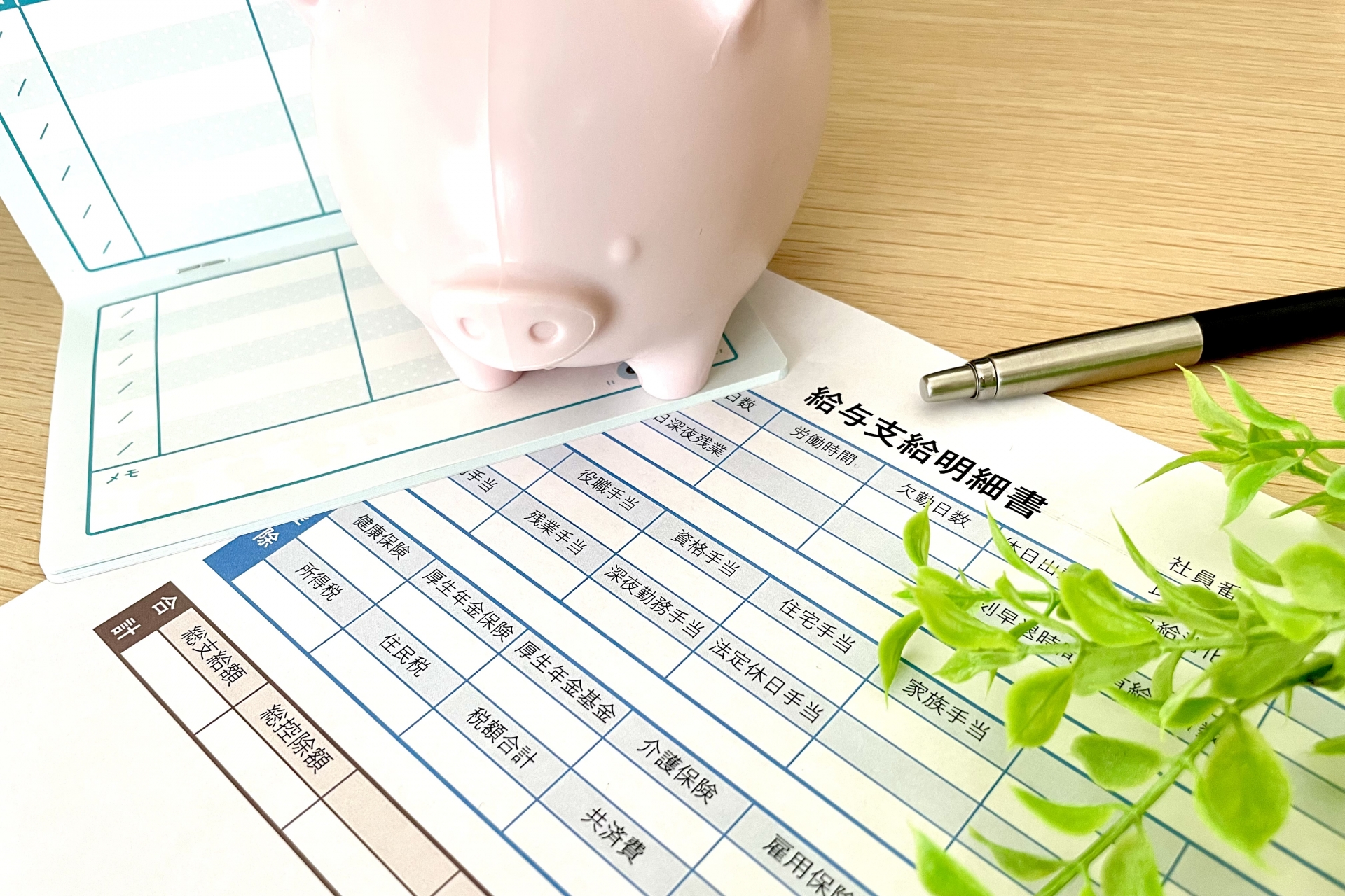 給与明細と通帳と貯金箱